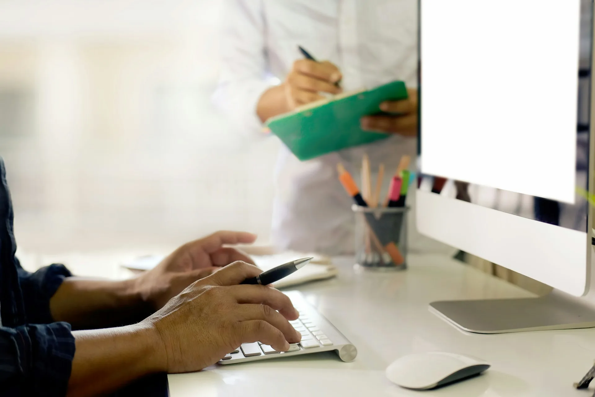 accounting team member consulting another at their desk