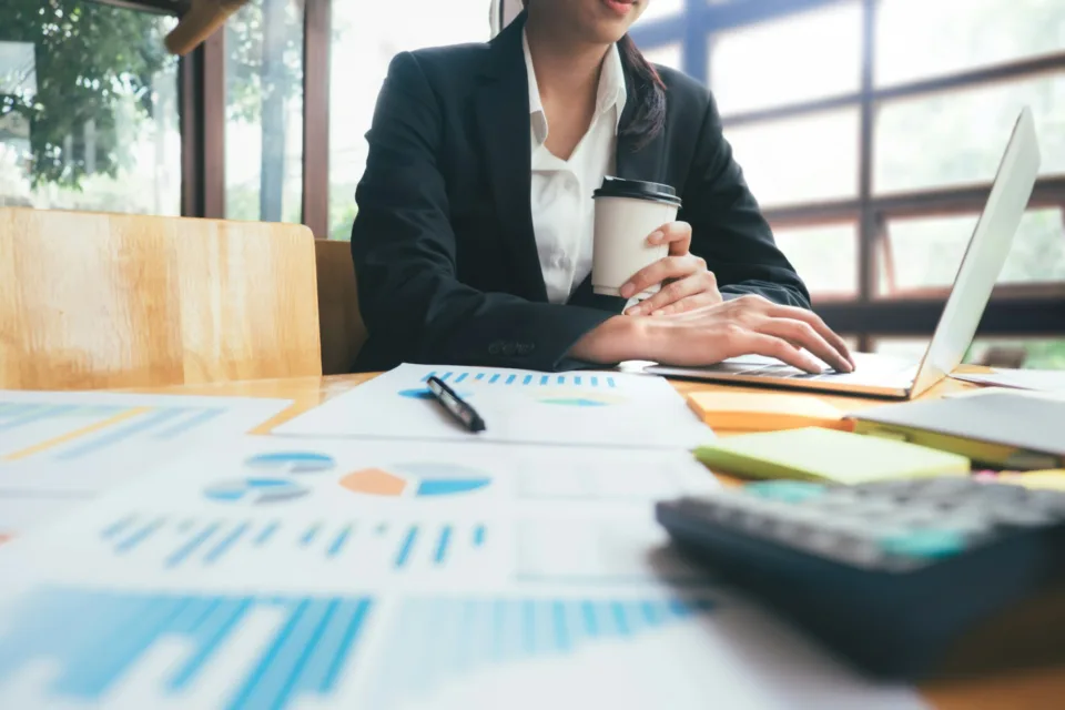 woman drinking coffee at desk while working