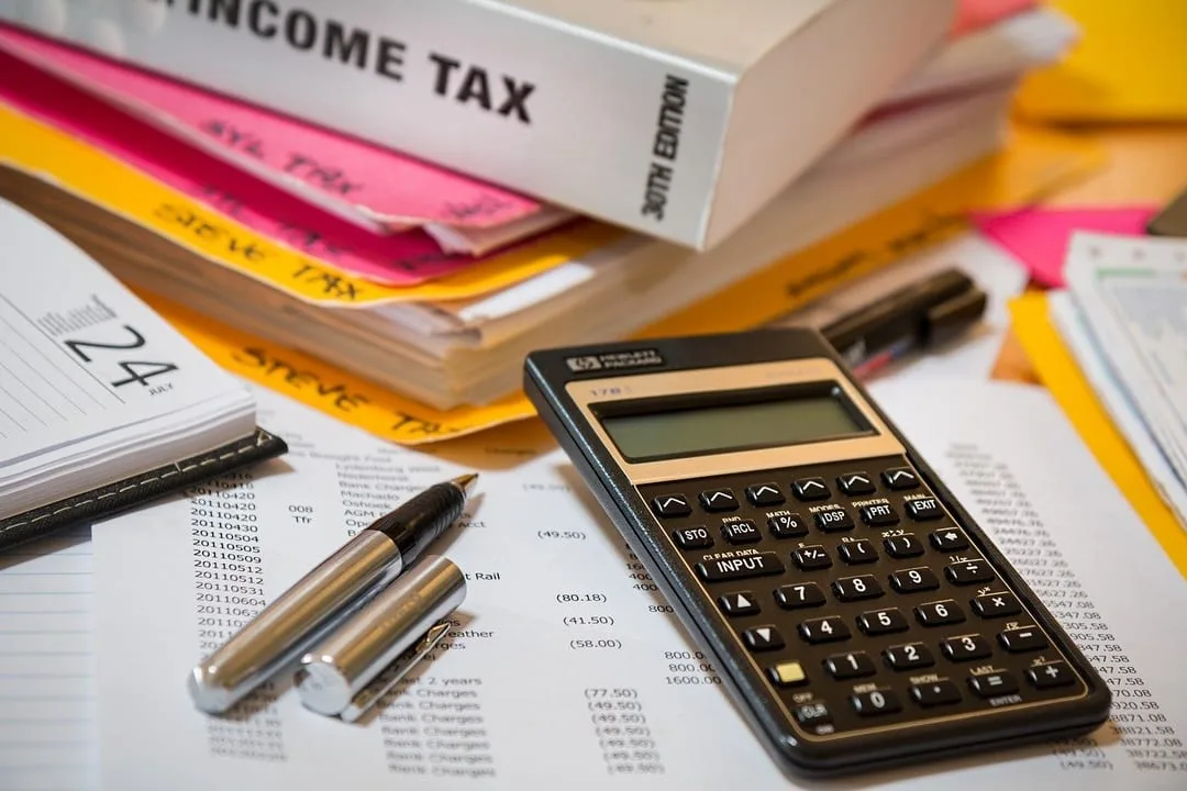 pile of papers on accountant's desk along with a calculator
