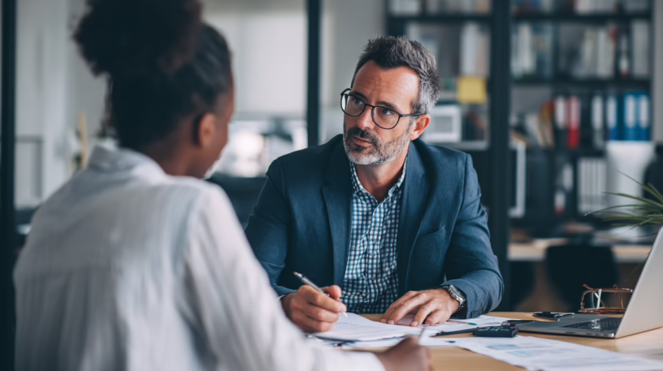 Accountant consulting with a client at a desk during a practice management software implementation meeting